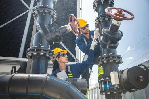 Contractor in a hard hat working on industrial piping